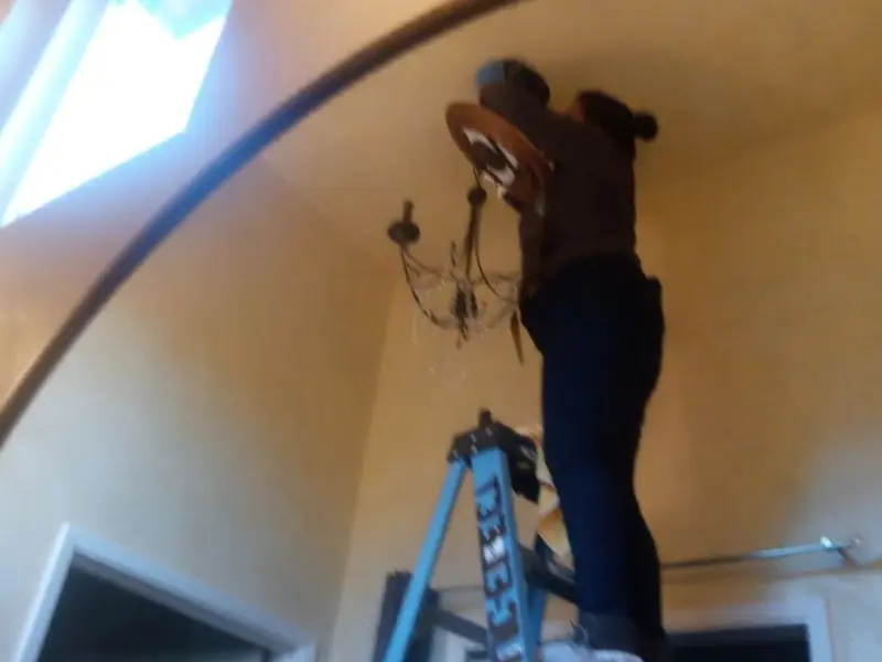 Electrician installing a chandelier in a La CaÃÂ±ada Flintridge residence